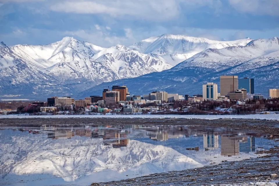 Anchorage, Alaska skyline with snowy mountains in background.